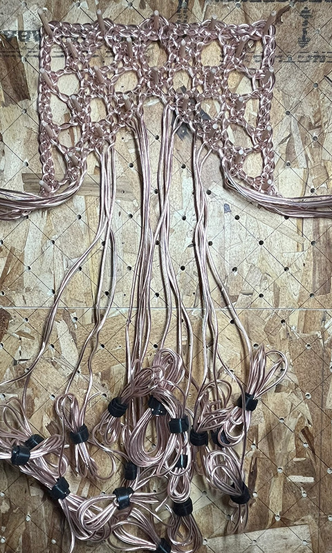 Working the bobbin lace pattern in speaker wire. 
