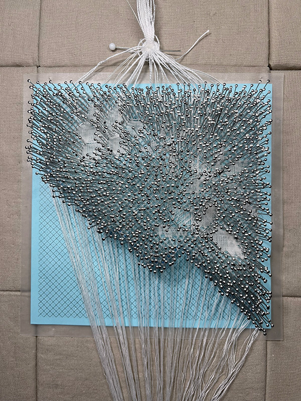 Reality Torchon bobbin lace in progress with an intentionally fragmented pattern.