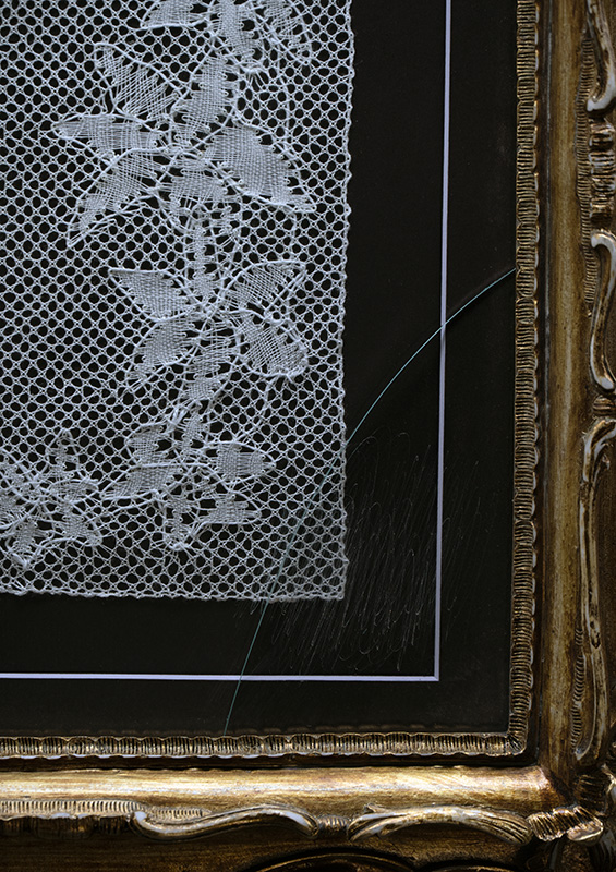 Cracked glass across the framed Disillusion bobbin lace.