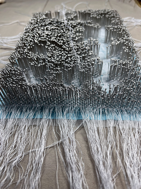 Utopia Flanders lace covered by a dense forest of pins near completion.