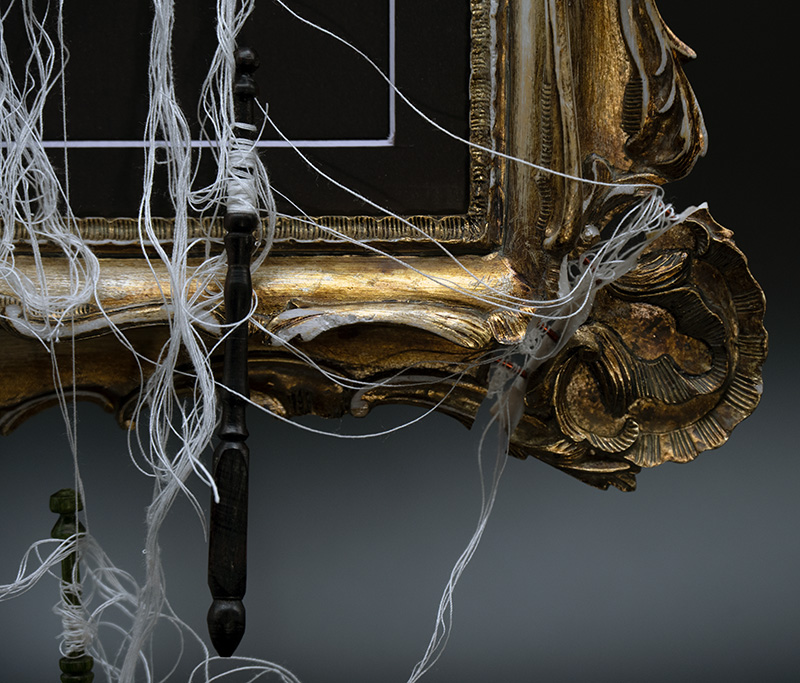 Tangled lace threads and bobbins extending through the broken Reality frame
