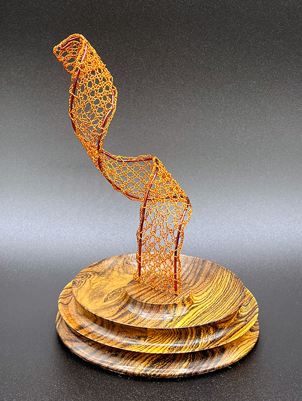 View 1 of bobbin lace sculpture with a wooden base.