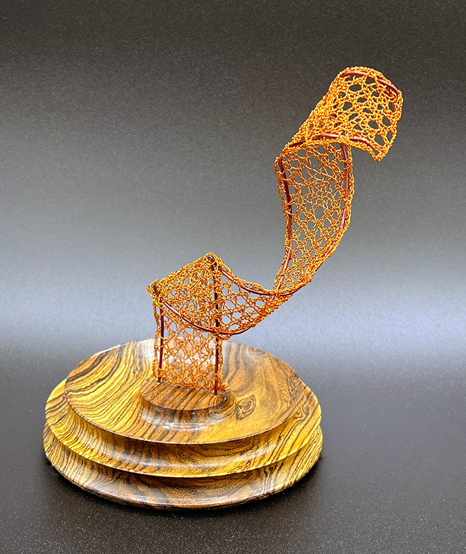 View 3 of bobbin lace sculpture with a wooden base.