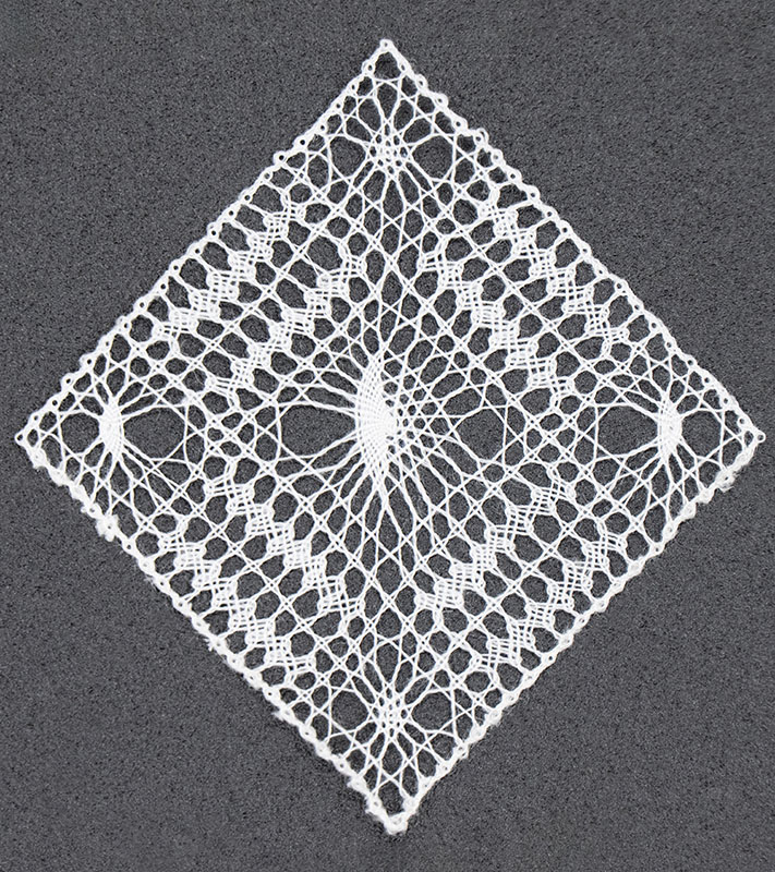 Gossamer micro bobbin lace artwork measuring 1.25 inches square.