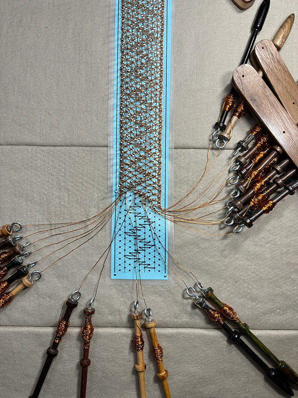 Wide strip of bobbin lace made with copper wire.