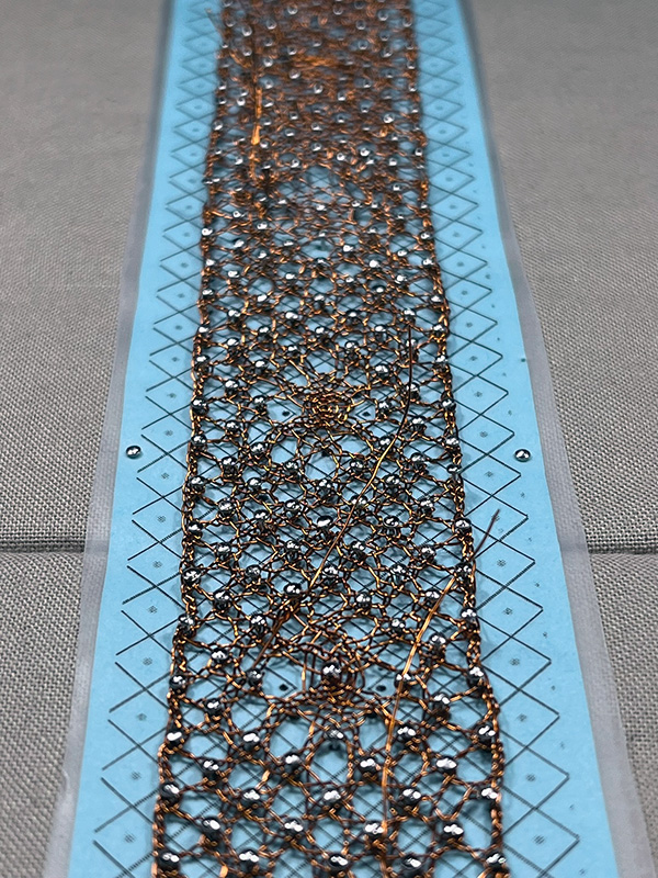 Wire bobbin lace on the pillow at an angle.